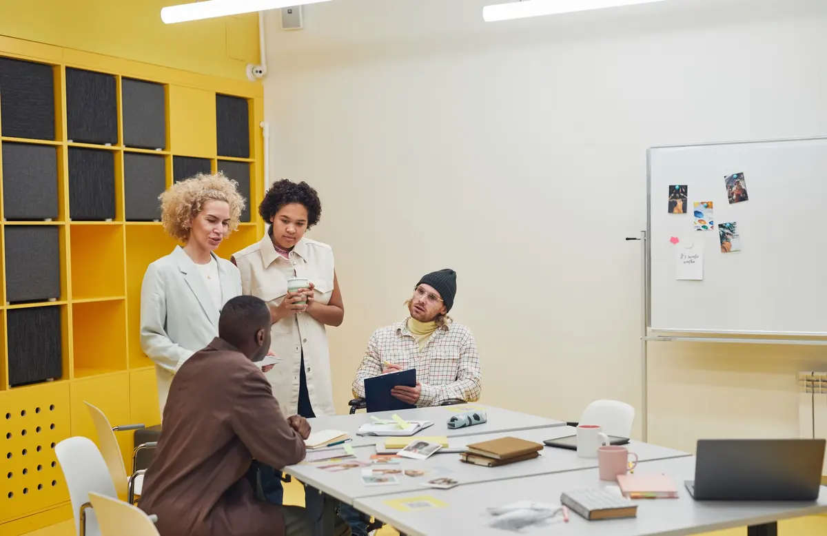Equipo que conversa junto a una mesa de trabajo con documentos