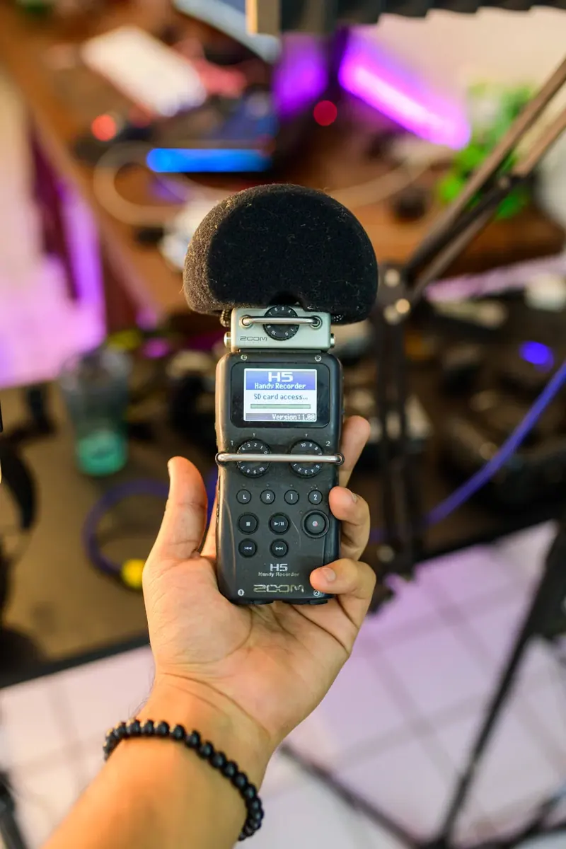 Mano que sostiene una grabadora de audio con micrófonos