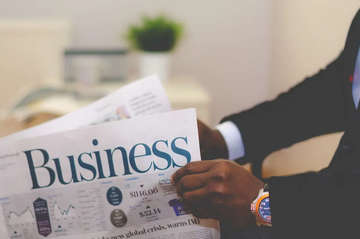 Persona que lee la sección de negocios de un periódico