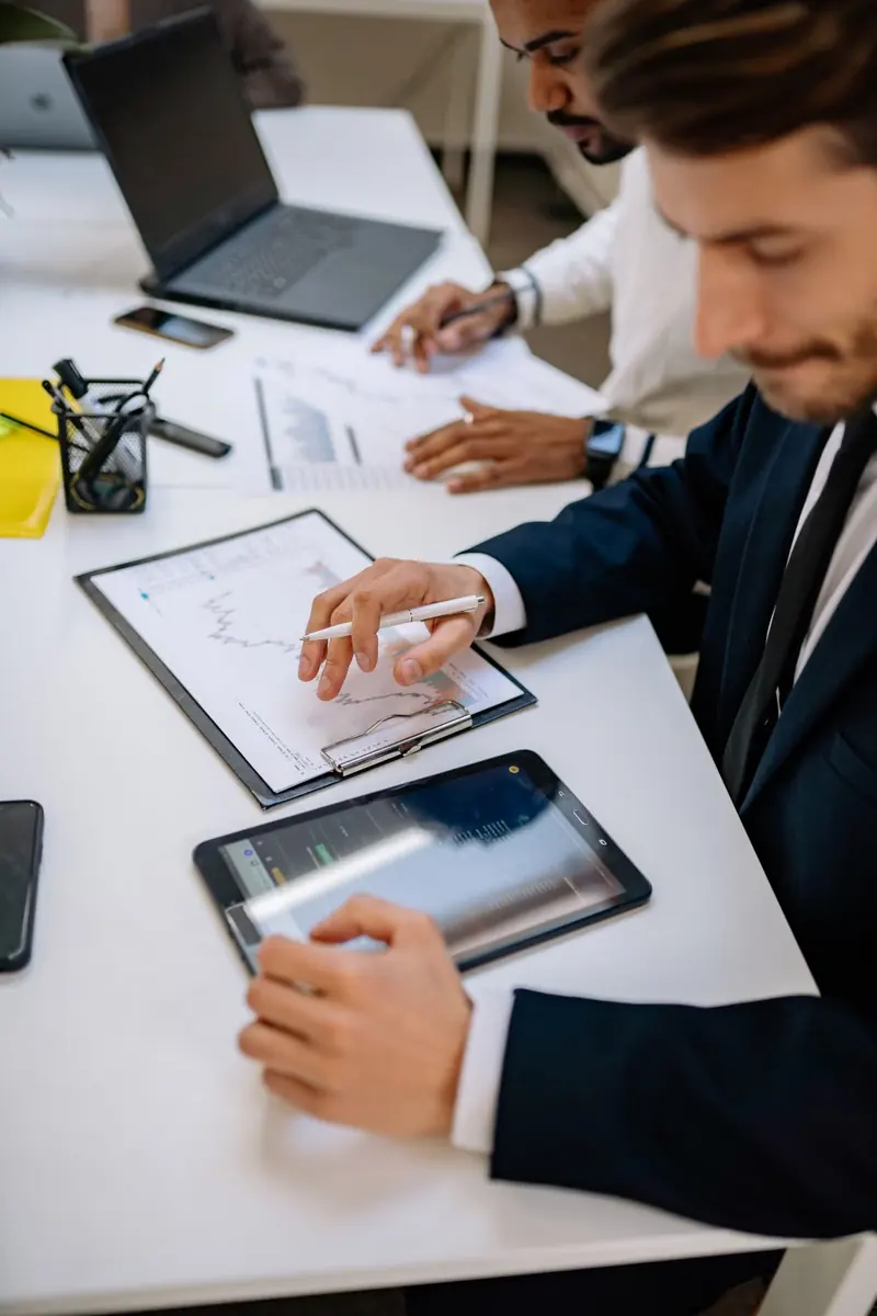 Profesionales revisan documentos con una tableta sobre la mesa
