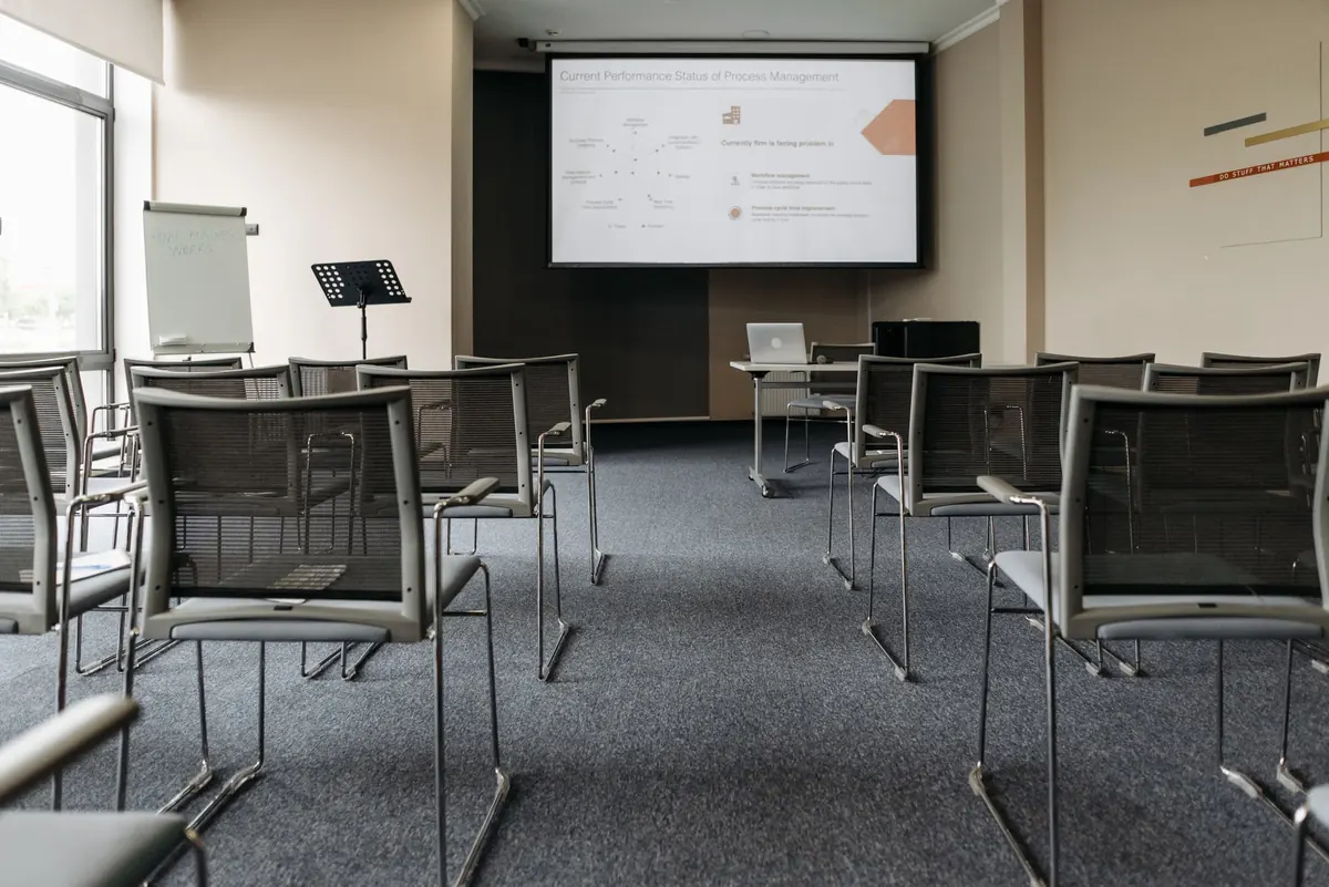 Sala con sillas y una pantalla preparada para una presentación